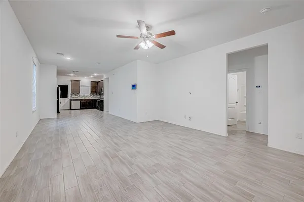 a view of a livingroom with furniture a ceiling fan and wooden floor