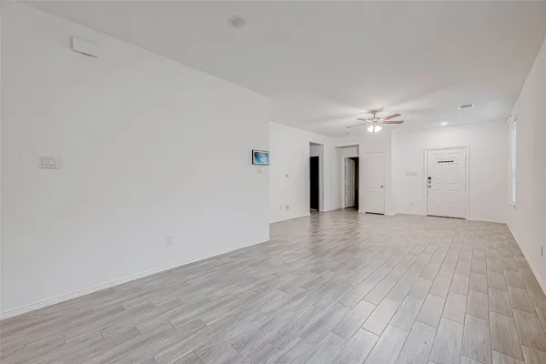 a view of an empty room with wooden floor