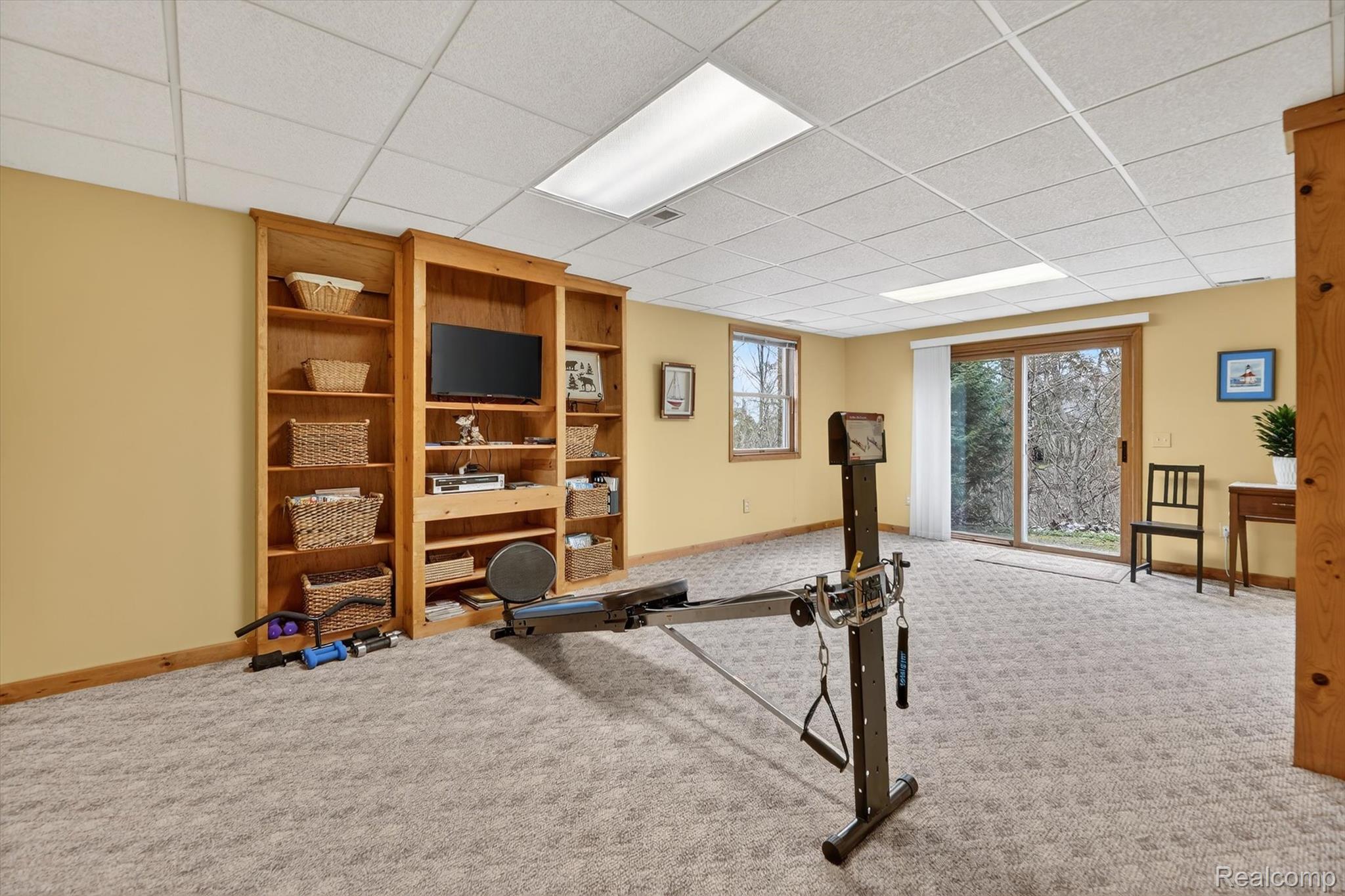 7798 Lee Road Brighton, MI 48116 - Photo 32 of 49 Workout room with carpet flooring and a paneled ceiling