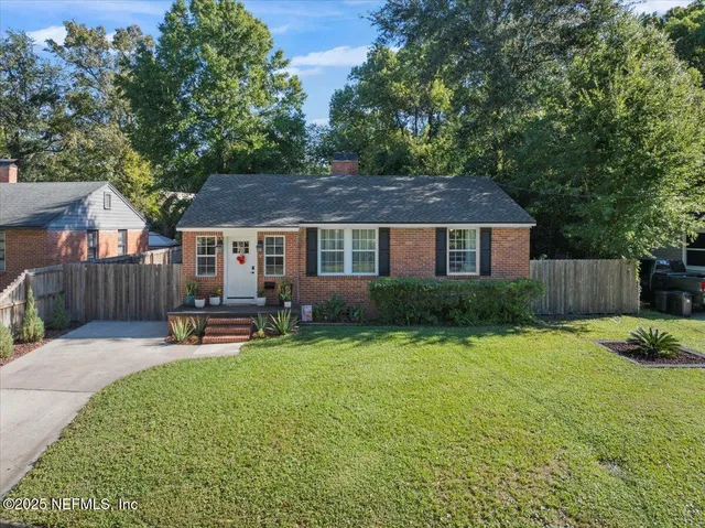 a view of a house with a yard and sitting area