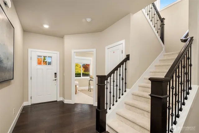 a view of a hallway with wooden floor and staircase