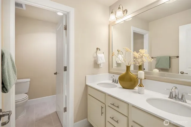 a bathroom with a granite countertop sink a toilet and a mirror
