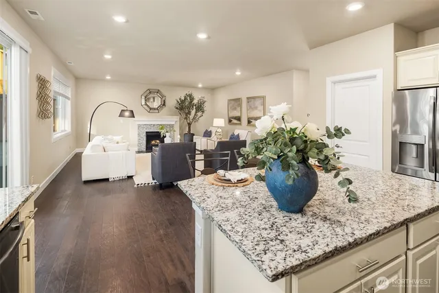 a living room with furniture potted plant and a refrigerator