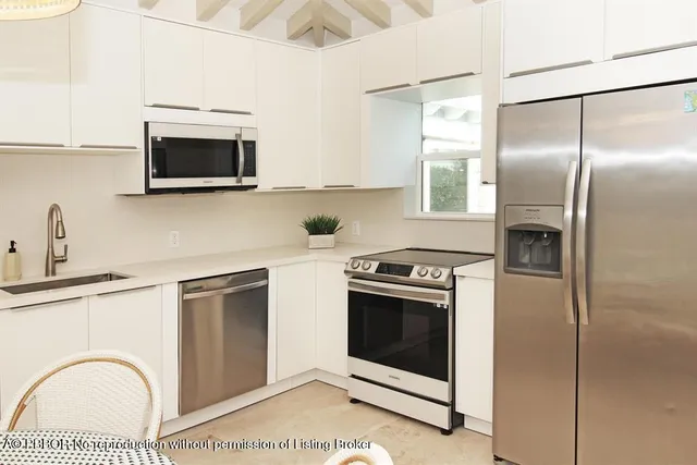 a kitchen with stainless steel appliances granite countertop a stove a refrigerator and a microwave