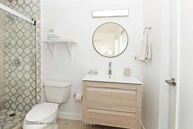 a bathroom with a toilet sink vanity and mirror