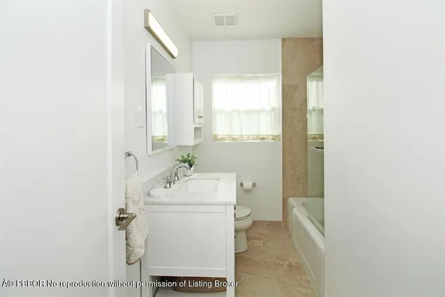 a bathroom with a sink toilet and window