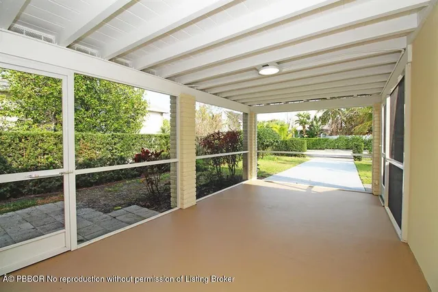 a view of empty room with wooden floor and floor to ceiling window