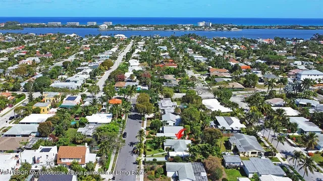 an aerial view of residential houses with outdoor space and trees