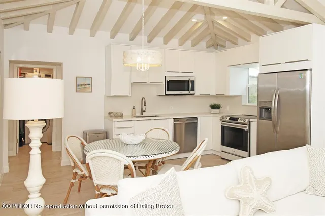 a kitchen with kitchen island a appliances dining table and chairs