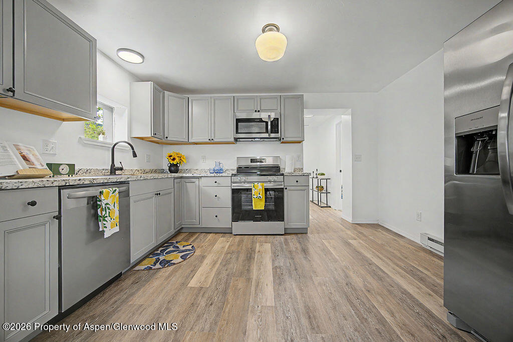 54 South Ranney Street Craig, CO 81625 - Photo 3 of 32 a kitchen with stainless steel appliances granite countertop a sink cabinets and wooden floor