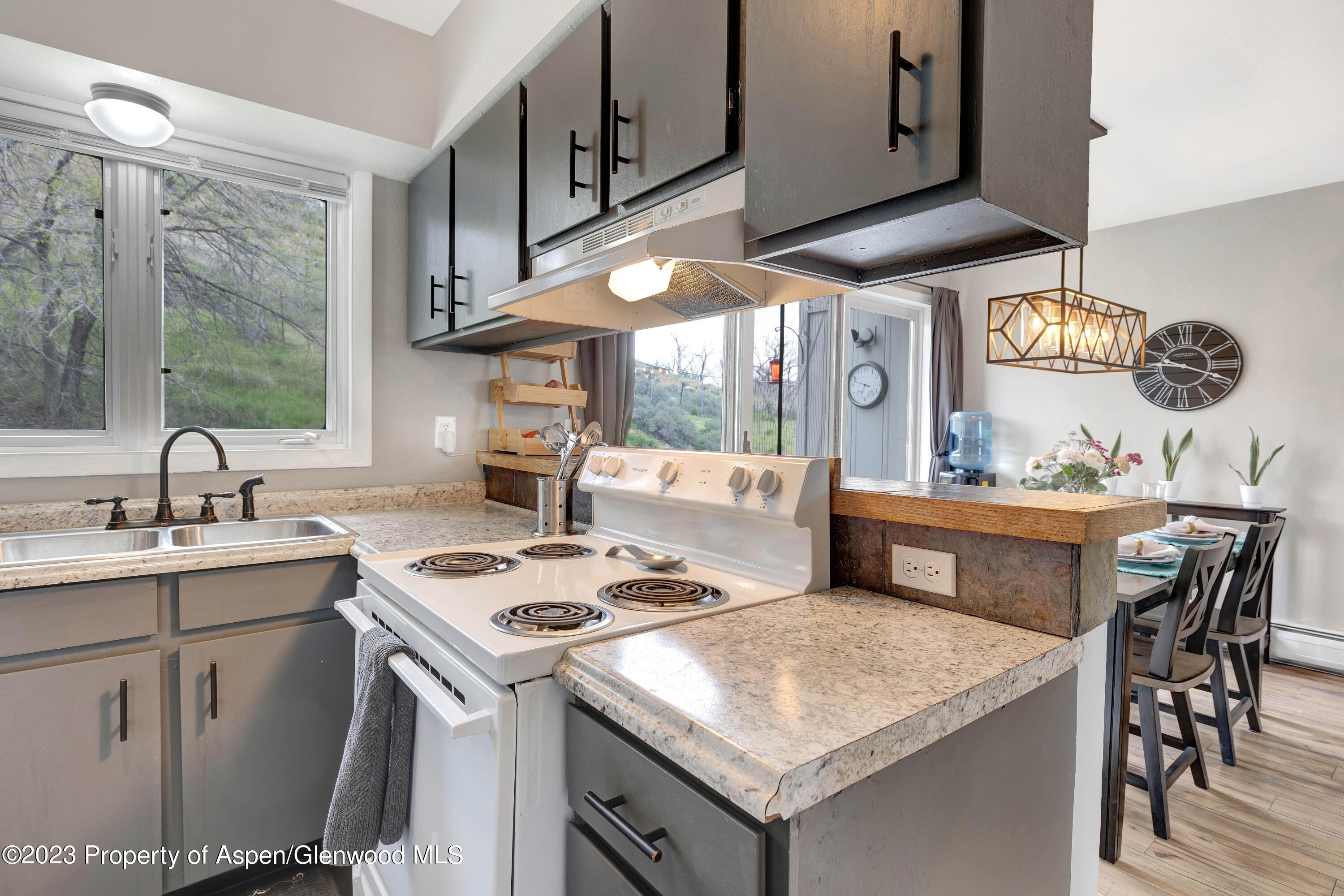 a kitchen with a sink a stove and chairs