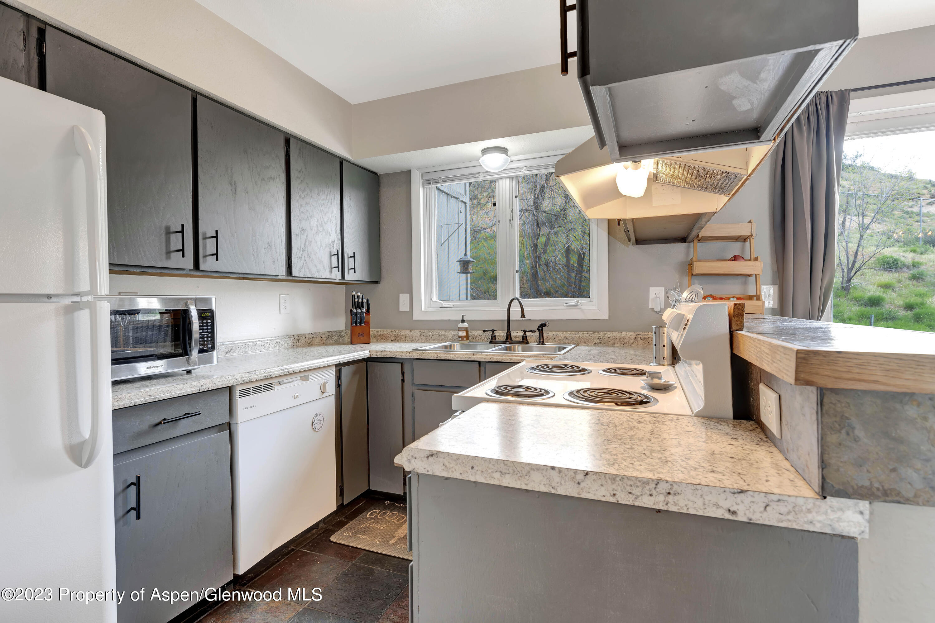 1173 Park Avenue Rifle, CO 81650 - Photo 8 of 26 a kitchen with granite countertop a sink a counter top space and stainless steel appliances