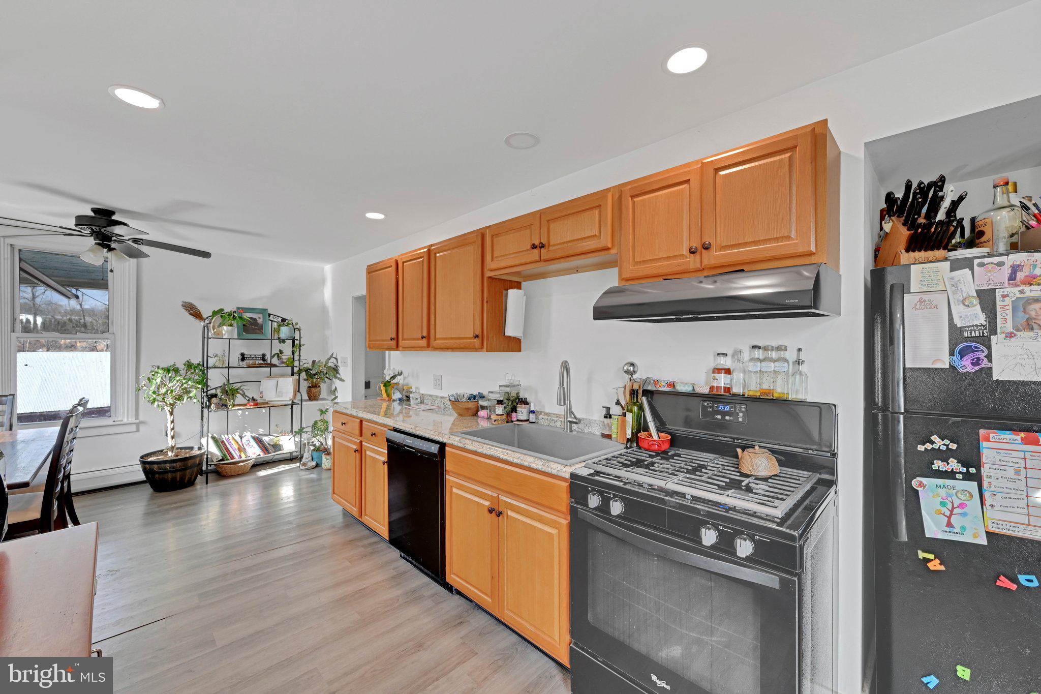 235 Stump Road Kutztown, PA 19530 - Photo 23 of 38 a kitchen with stainless steel appliances granite countertop a stove a sink dishwasher and a refrigerator with wooden floor