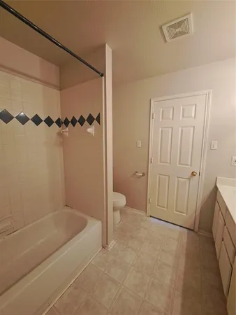 a bathroom with a granite countertop sink a toilet and shower