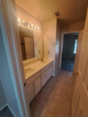 a bathroom with a double vanity sink and mirror with shower