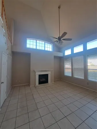 a view of an empty room with a fireplace and a window
