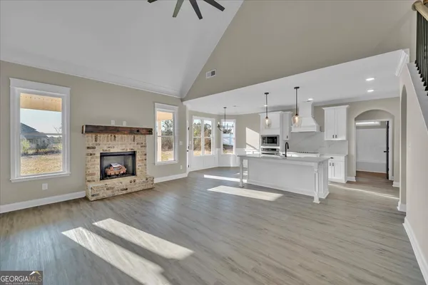 a view of a livingroom with wooden floor and a ceiling fan