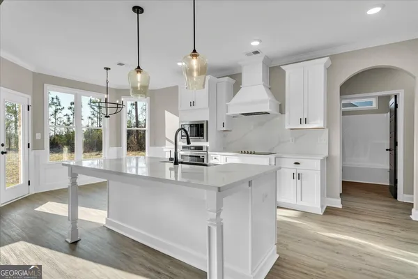 a kitchen with white cabinets and appliances