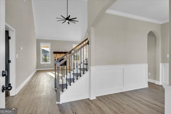 a view of a hallway with wooden floor and stairs