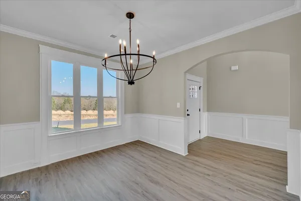 a view of empty room with wooden floor and window