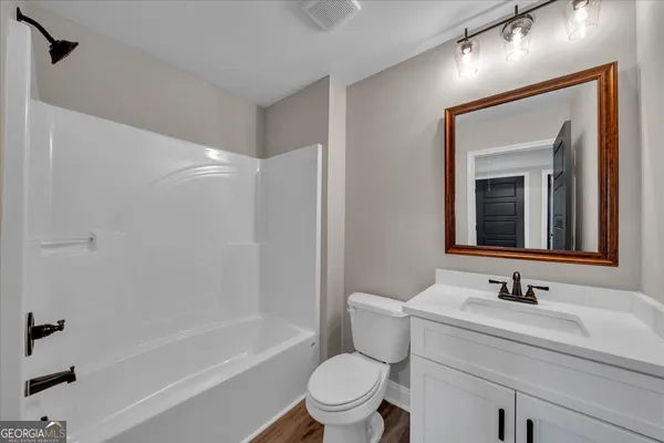 a bathroom with a sink toilet vanity and tub