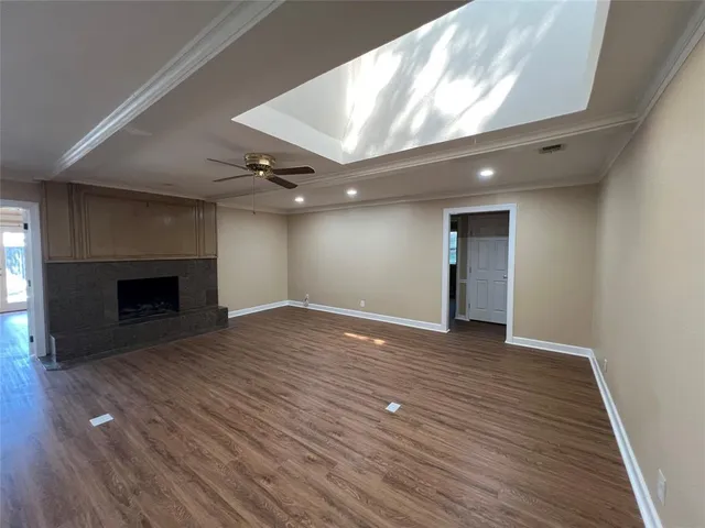an empty room with wooden floor and fireplace