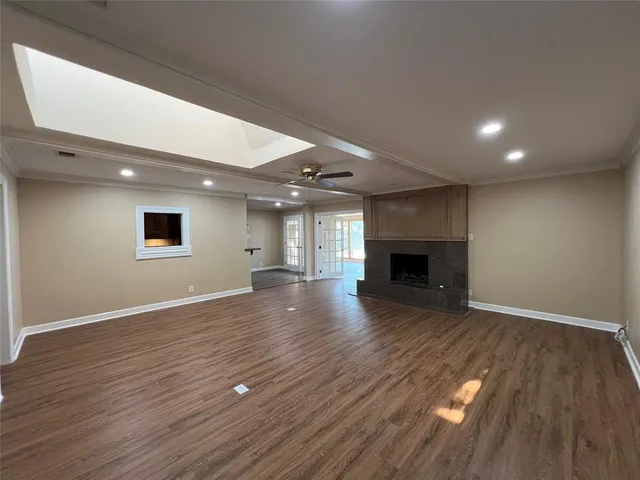 an empty room with wooden floor and fireplace