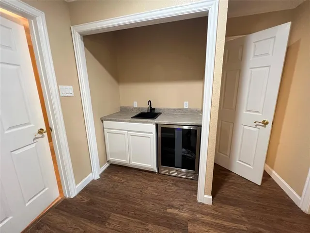 a kitchen with a sink a refrigerator and wooden floor