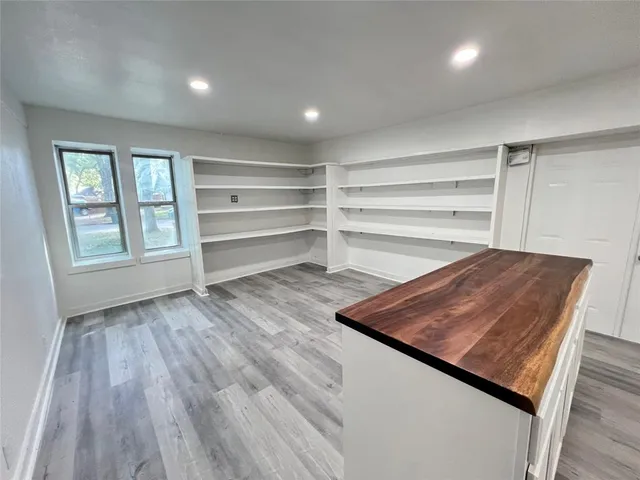 a large kitchen with a wooden floor and outdoor space