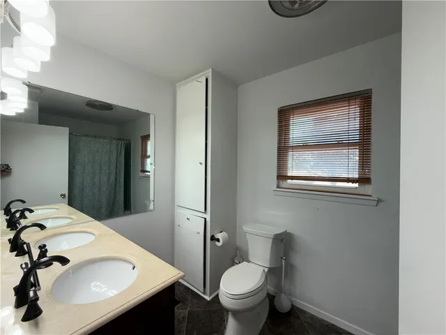 a bathroom with a tub a sink and a window