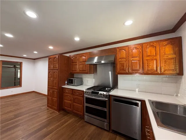 a kitchen with stainless steel appliances granite countertop a stove and a sink