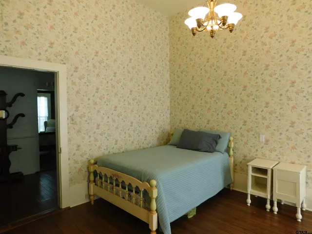 a bedroom with a bed and a chandelier