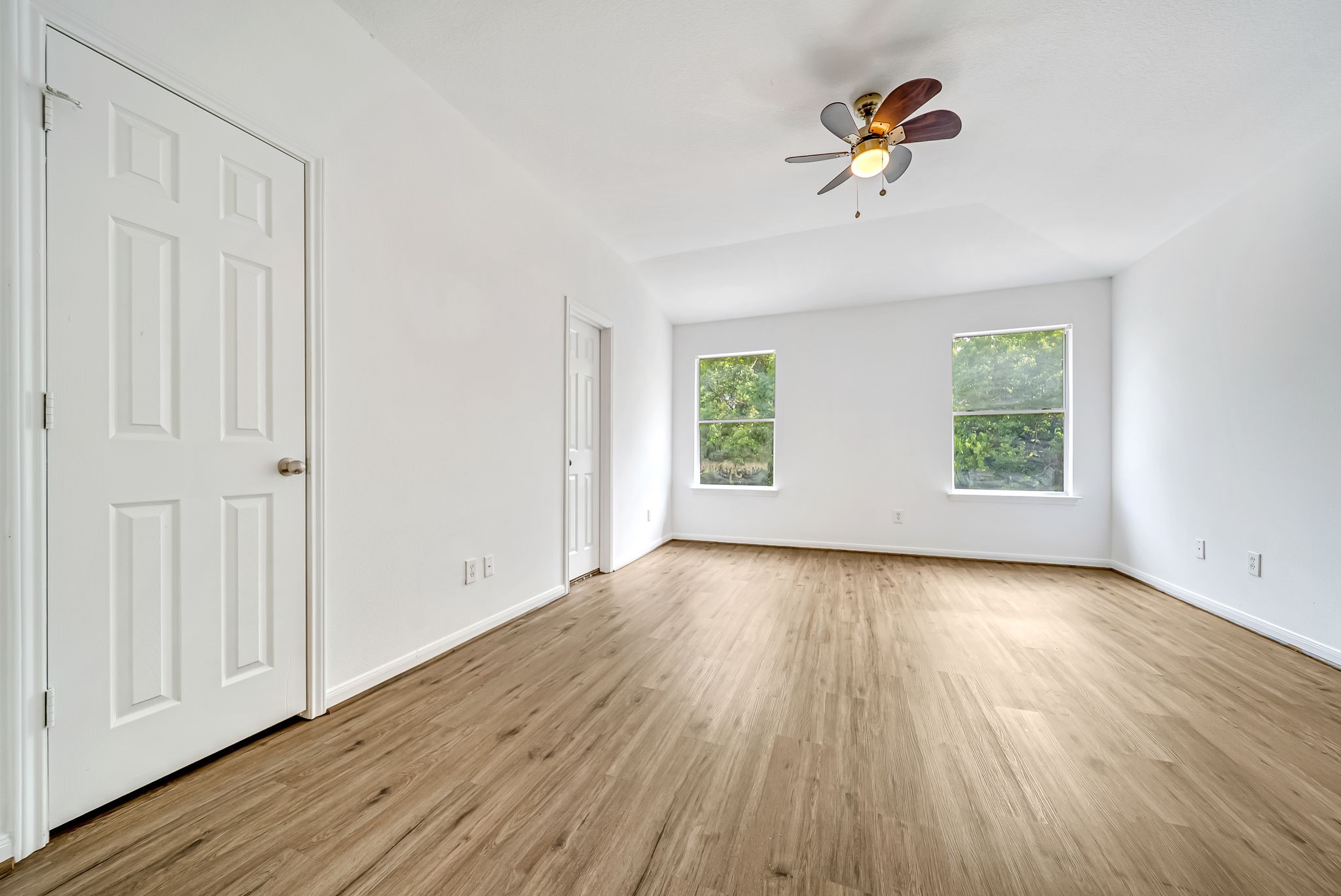 23526 Whispering Maple Drive Spring, TX 77373 - Photo 13 of 26 an empty room with wooden floor chandelier fan and windows