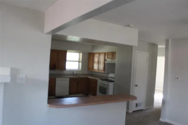 a kitchen with stainless steel appliances granite countertop a sink and a refrigerator
