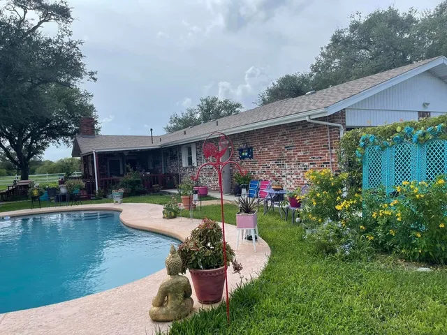 a view of a house with swimming pool and furniture
