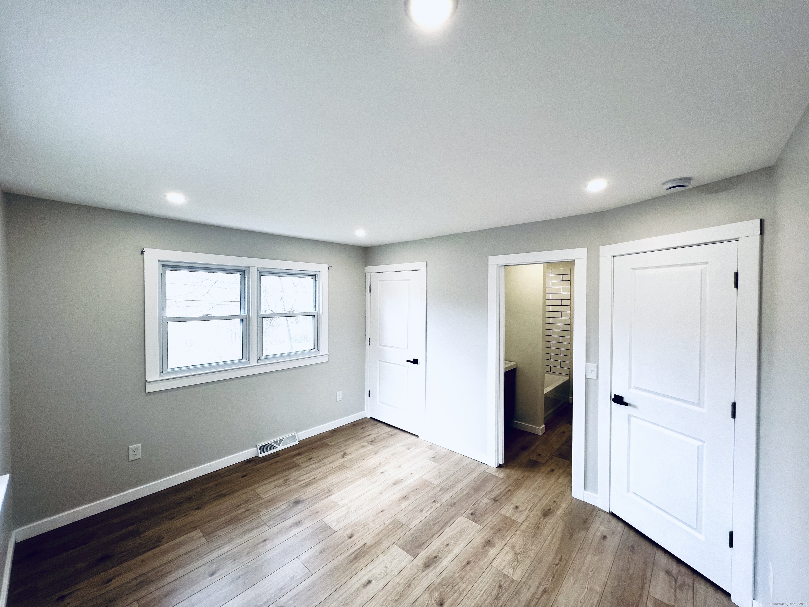 8 Rustic Road Ridgefield, CT 06877 - Photo 10 of 18 an empty room with wooden floor and windows