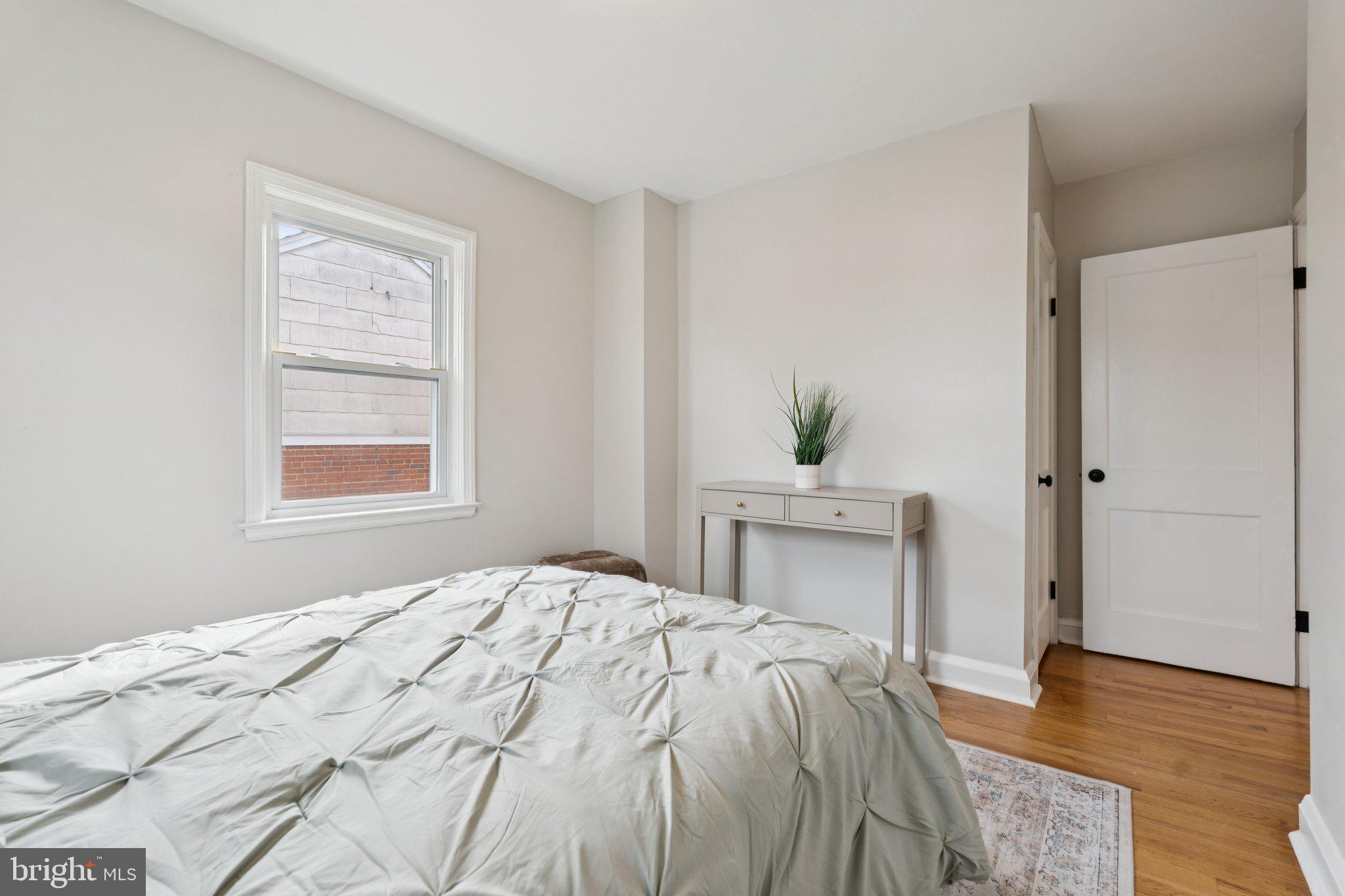 1014 Upnor Road Baltimore, MD 21212 - Photo 16 of 25 a bedroom with a bed potted plant on dresser and a window