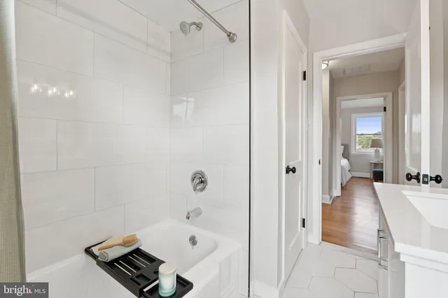a bathroom with a tub shower and sink