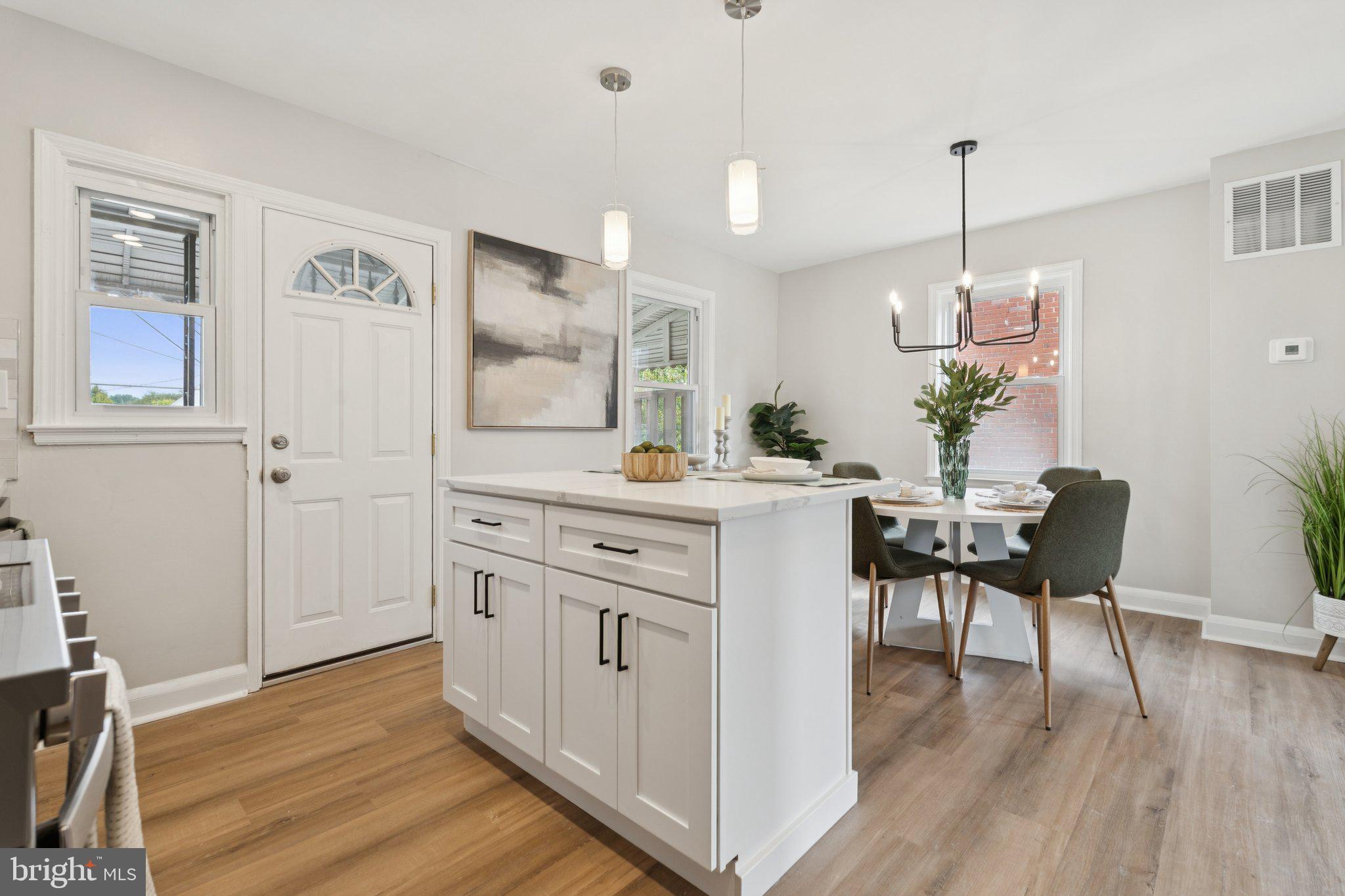 1014 Upnor Road Baltimore, MD 21212 - Photo 6 of 25 a kitchen with a table chairs refrigerator and microwave