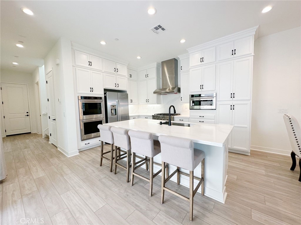 478 Chorus Irvine, CA 92618 - Photo 4 of 33 a kitchen with stainless steel appliances a dining table chairs stove refrigerator and cabinets
