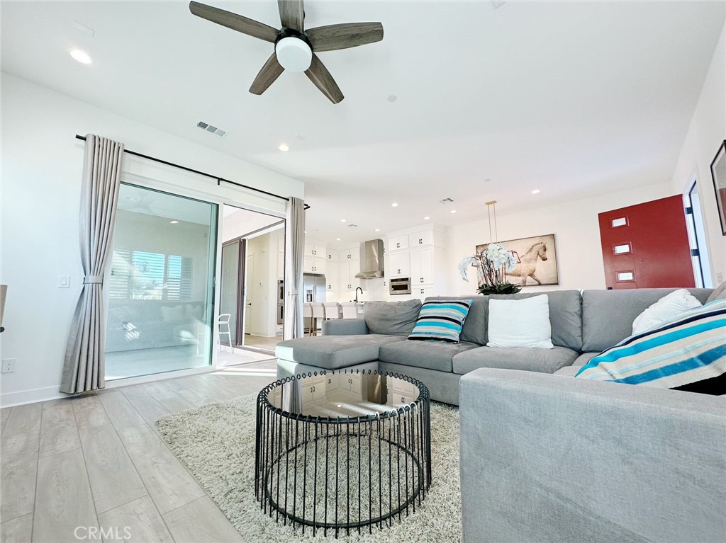 478 Chorus Irvine, CA 92618 - Photo 8 of 33 a living room with furniture a ceiling fan and a rug
