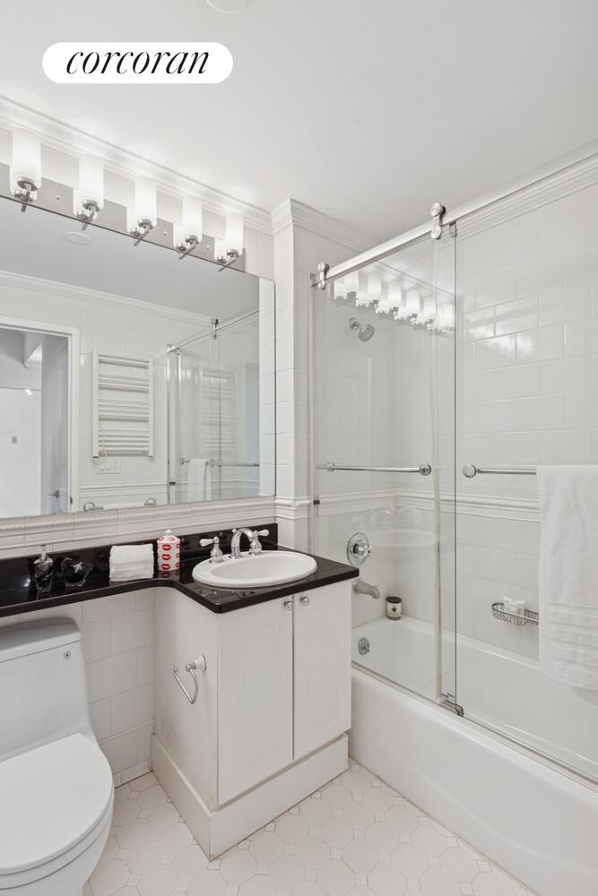 404 East 76th Street, Unit 2J Manhattan, NY 10021 - Photo 5 of 9 a bathroom with a sink a toilet and shower