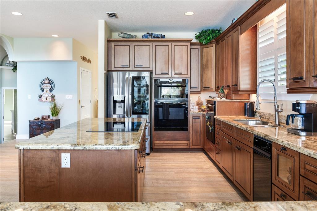 16480 Redington Drive Redington Beach, FL 33708 - Photo 17 of 93 a kitchen with kitchen island granite countertop a large counter top stainless steel appliances a sink and cabinets