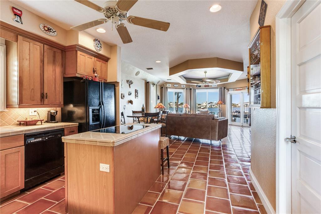 16480 Redington Drive Redington Beach, FL 33708 - Photo 43 of 93 a kitchen with stainless steel appliances a stove a sink dishwasher and a dining table with cabinets