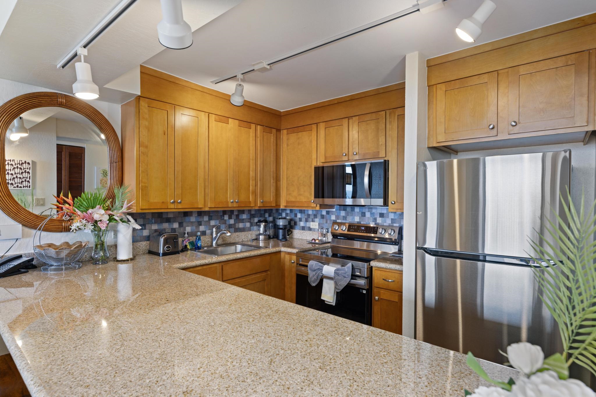 3445 Lower Honoapiilani Road, Unit 826 Lahaina, HI 96761 - Photo 9 of 26 a kitchen with stainless steel appliances granite countertop a sink a stove and a refrigerator