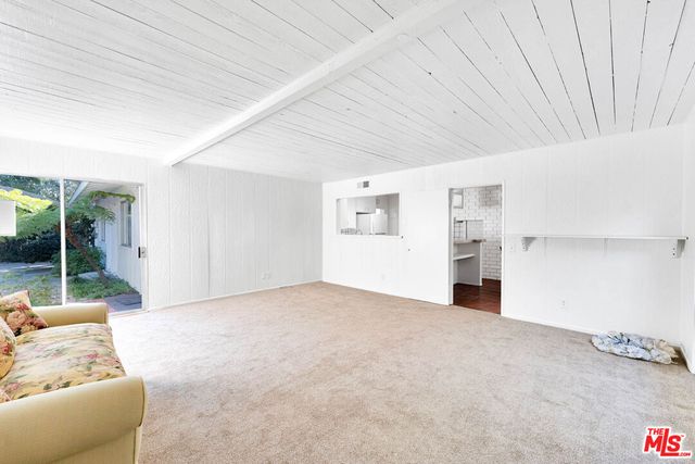 a kitchen with stainless steel appliances kitchen island wooden cabinets and a window