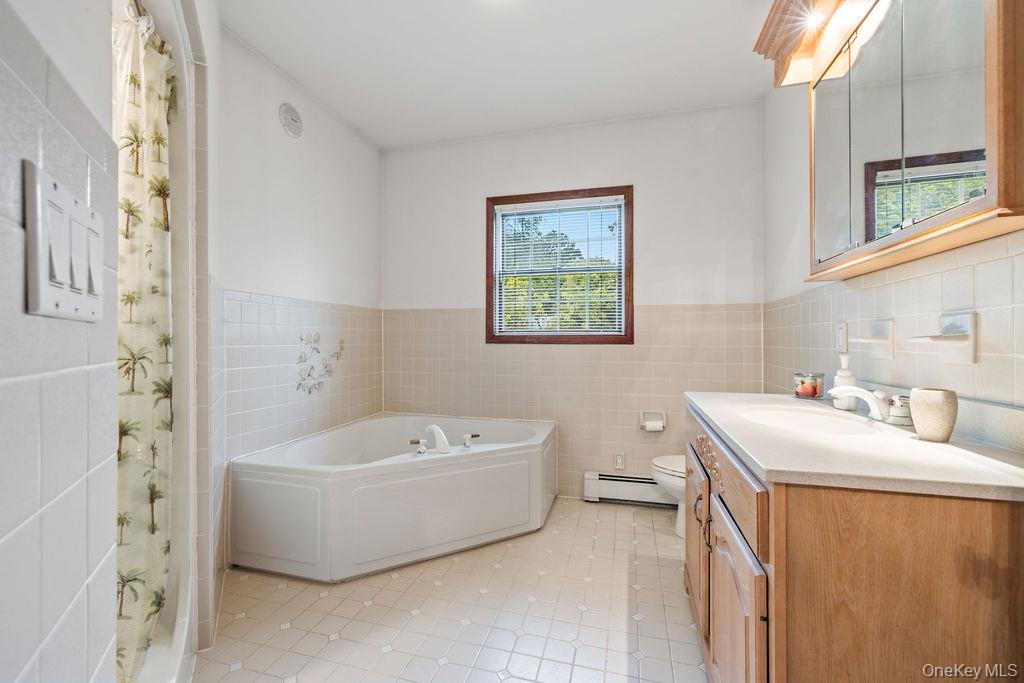 289 Seven Springs Mountain Road Monroe, NY 10950 - Photo 12 of 25 a bathroom with a sink a bathtub and a window