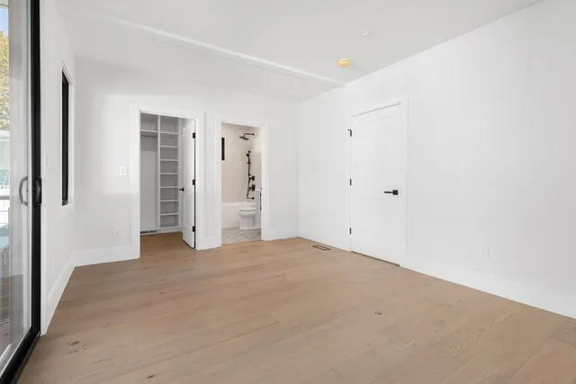 an empty room with closet and mirror