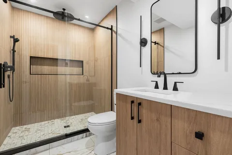 a bathroom with a sink a toilet and shower