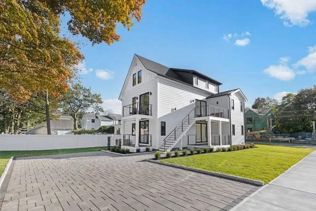 a view of a white house with a yard